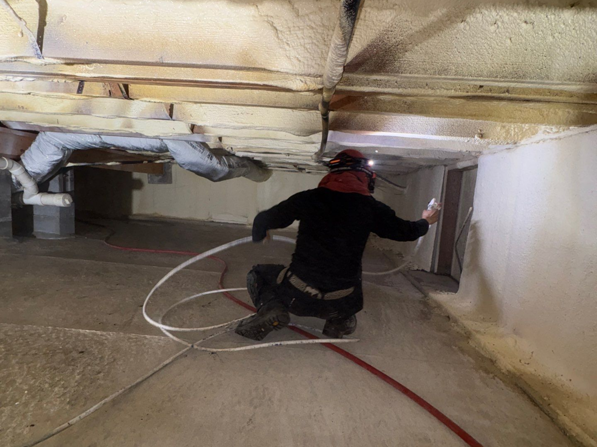 crawlspace encapsulation technician applying spray coating Hamptons NY