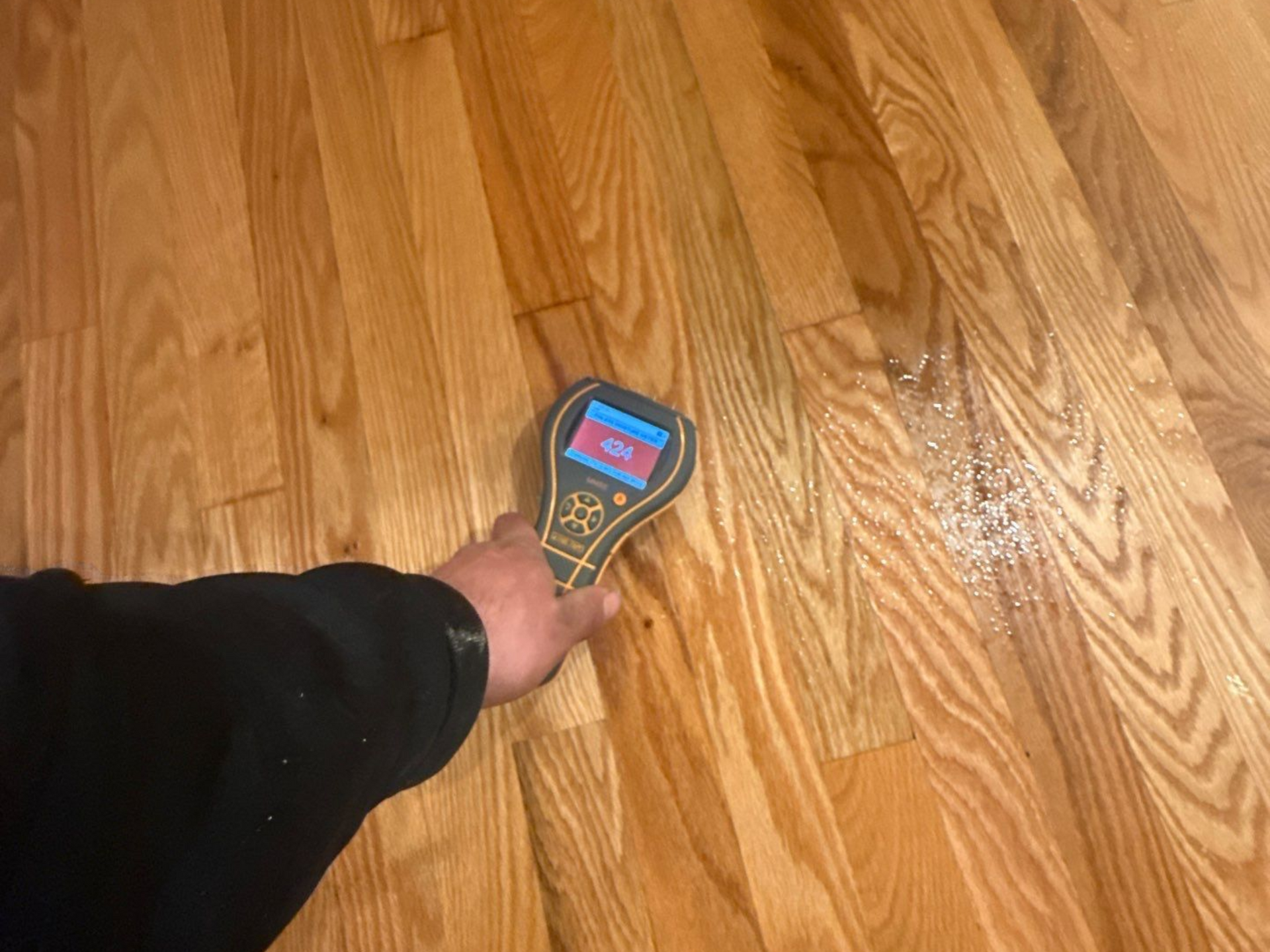 Taking moisture readings at a home in Quogue, NY after water damage from a flooded bathroom 