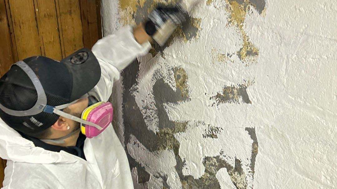 Professional technician applying mold encapsulation treatment in a Long Island basement