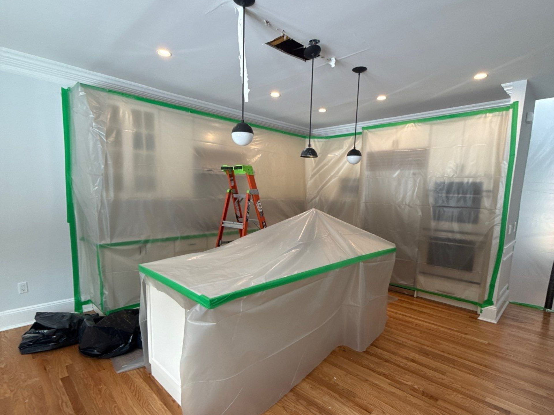 Water damage to hardwood flooring and ceiling at a home in Quogue, NY after water damage from a flooded bathroom 