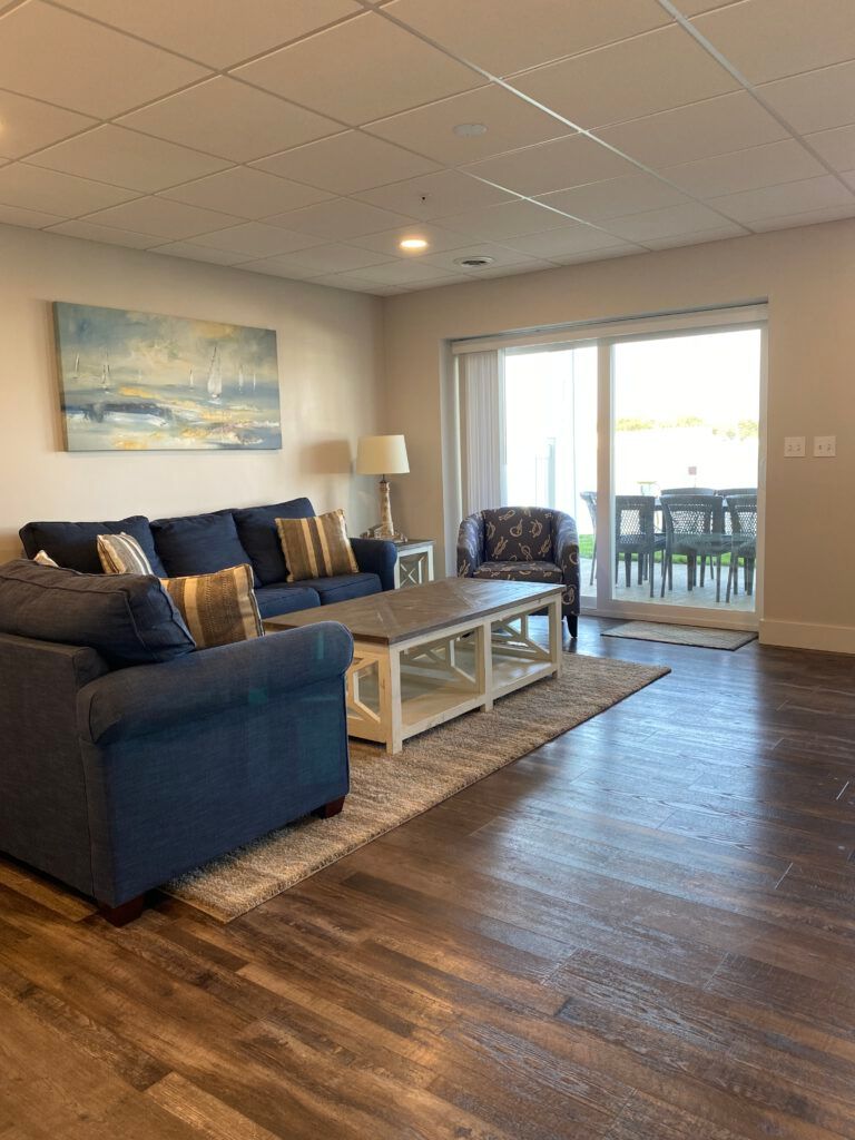 A living room with a couch , chair , coffee table and sliding glass doors.