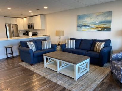 A living room with two blue couches and a coffee table.