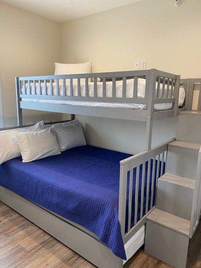A bunk bed with stairs leading up to it in a bedroom.