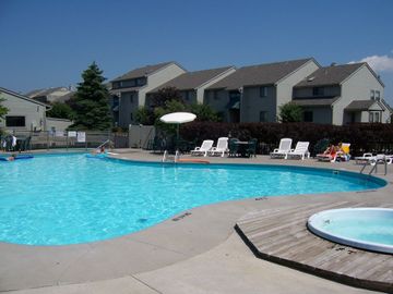 A large swimming pool surrounded by chairs and umbrellas