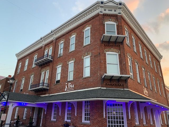 A large brick building with a lot of windows and a fire escape.