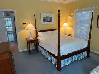 A bedroom with a four poster bed and two lamps