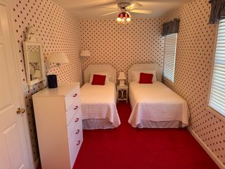 A bedroom with two twin beds and a ceiling fan