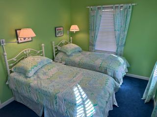 A bedroom with two twin beds and green walls