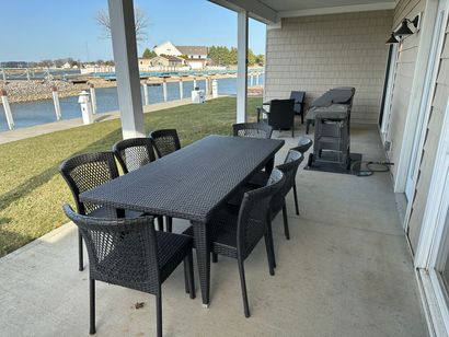 A patio with a table and chairs overlooking a body of water