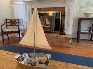 A small sailboat is sitting on a table in front of a fireplace