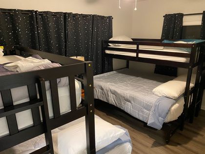 A bedroom with three bunk beds and two single beds.