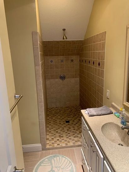 A bathroom with a walk in shower and a sink.