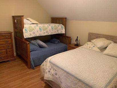 A bedroom with two beds and a bunk bed.