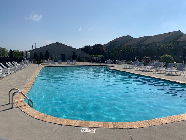 A large swimming pool with a lot of chairs around it