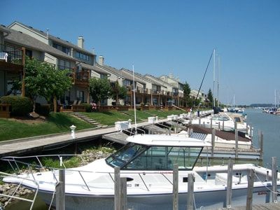 A boat is docked at a marina in front of a building.