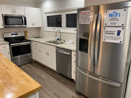 A kitchen with stainless steel appliances and a sign on the refrigerator that says wifi