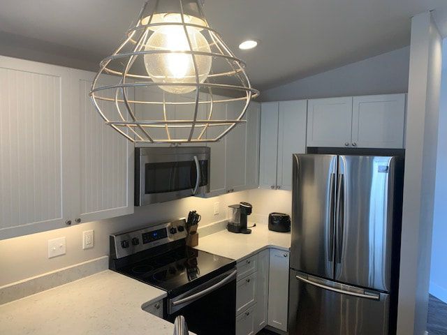 A kitchen with stainless steel appliances and white cabinets