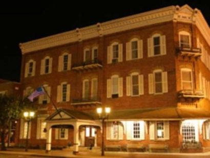 A large brick building with white shutters is lit up at night