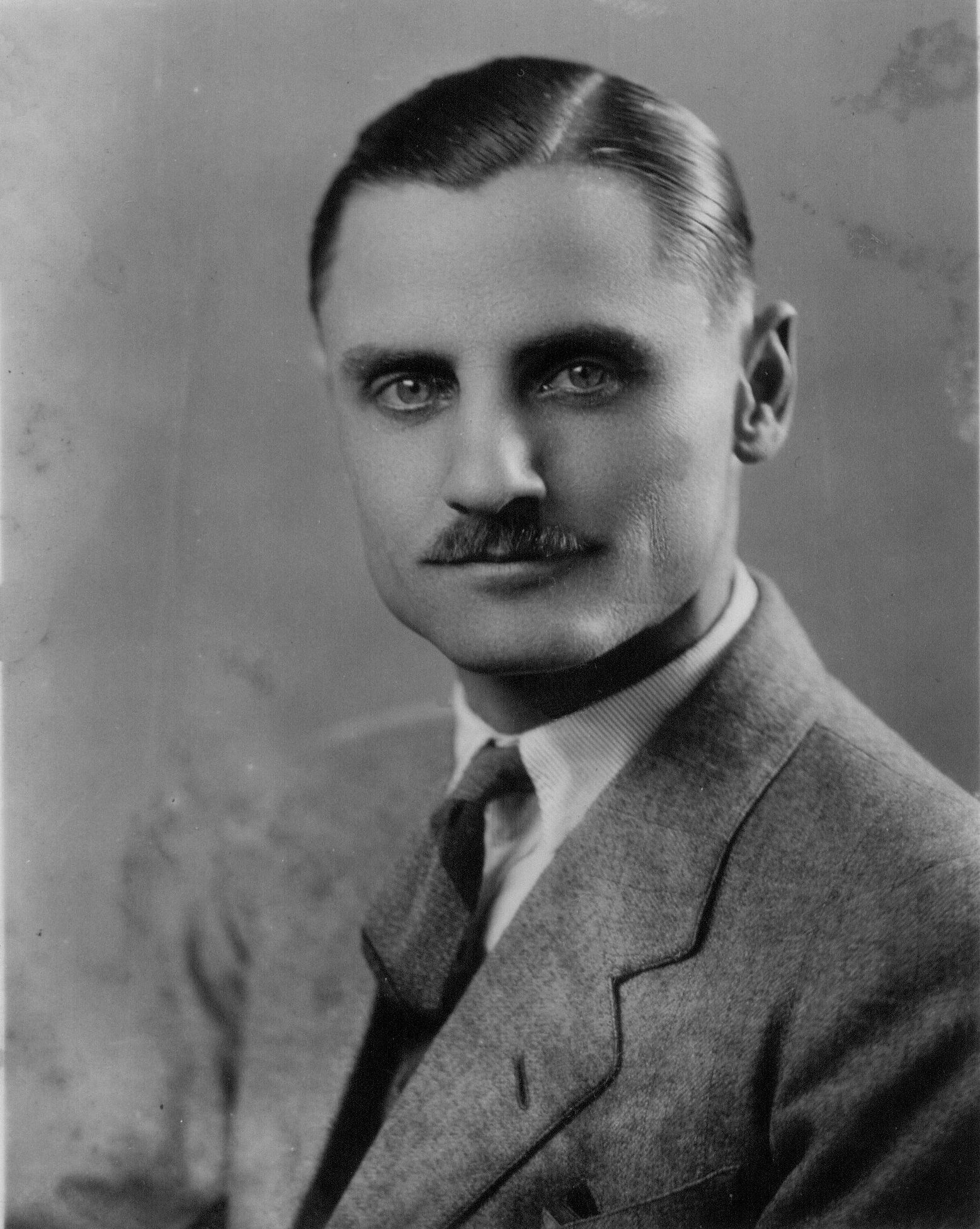 A man wearing a crown with the letter r on it