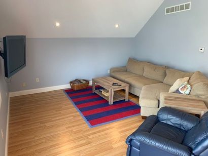 A living room with a couch , chair , coffee table and television.