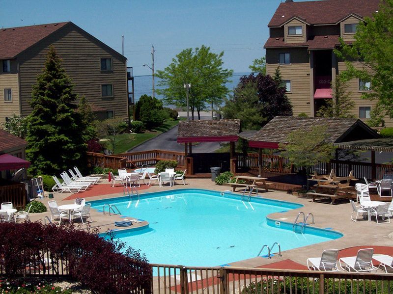 A large swimming pool surrounded by chairs and tables