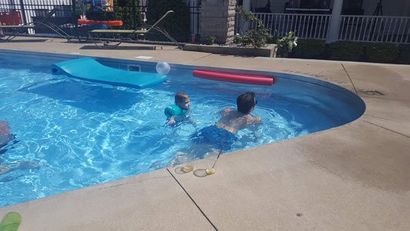 Two children are swimming in a swimming pool.