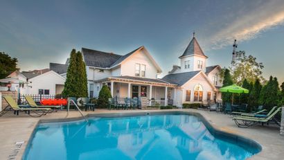 A large white house with a swimming pool in front of it