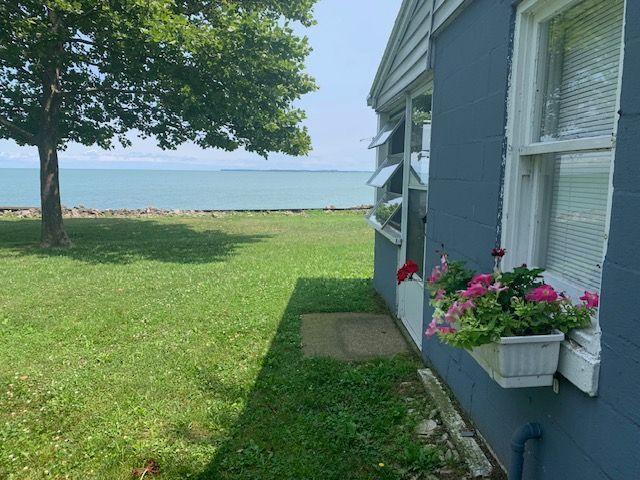 A blue house with a window looking out to the ocean