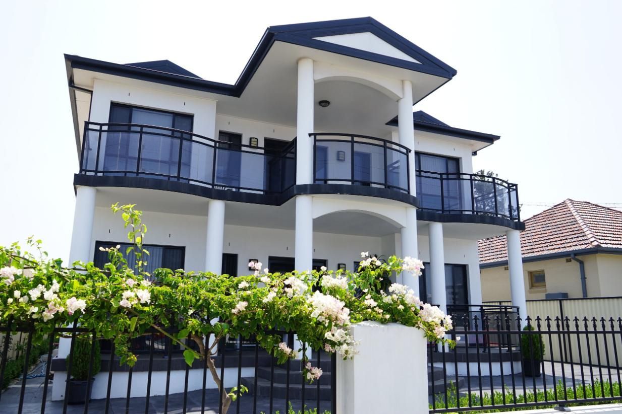 A Large White House With Balconies And A Black Fence — Rendering By Yilmaz P/L In Dapto, NSW