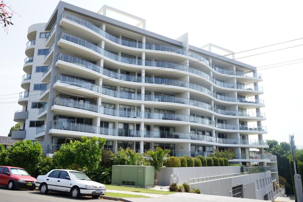 A Large Apartment Building With Cars Parked In Front Of It — Rendering By Yilmaz P/L In Wollongong, NSW