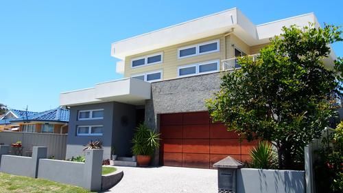 A Large Modern House With A Red Garage Door — Rendering By Yilmaz P/L In Wollongong, NSW