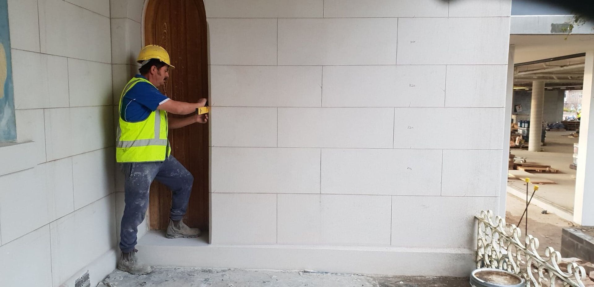 A Construction Worker Is Measuring A Hole In A Wall — Rendering By Yilmaz P/L In Wollongong, NSW