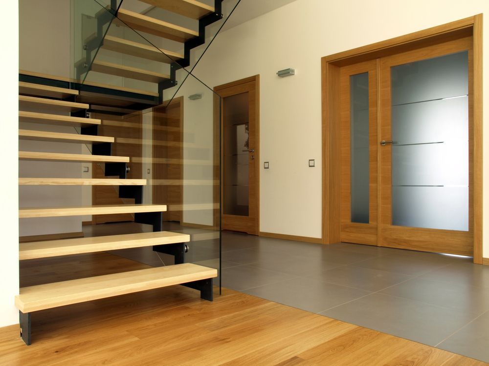A Wooden Staircase With a Glass Railing in a Hallway — Suncoast Kitchens In Bli Bli, QLD