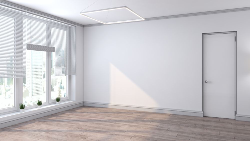 An Empty Room With a Wooden Floor, White Walls, and a Door — Suncoast Kitchens In Bli Bli, QLD