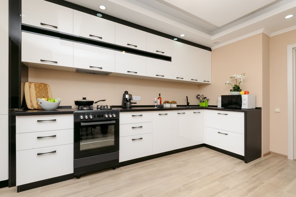 A Kitchen With Black and White Cabinets and a Stove — Suncoast Kitchens In Kunda Park, QLD