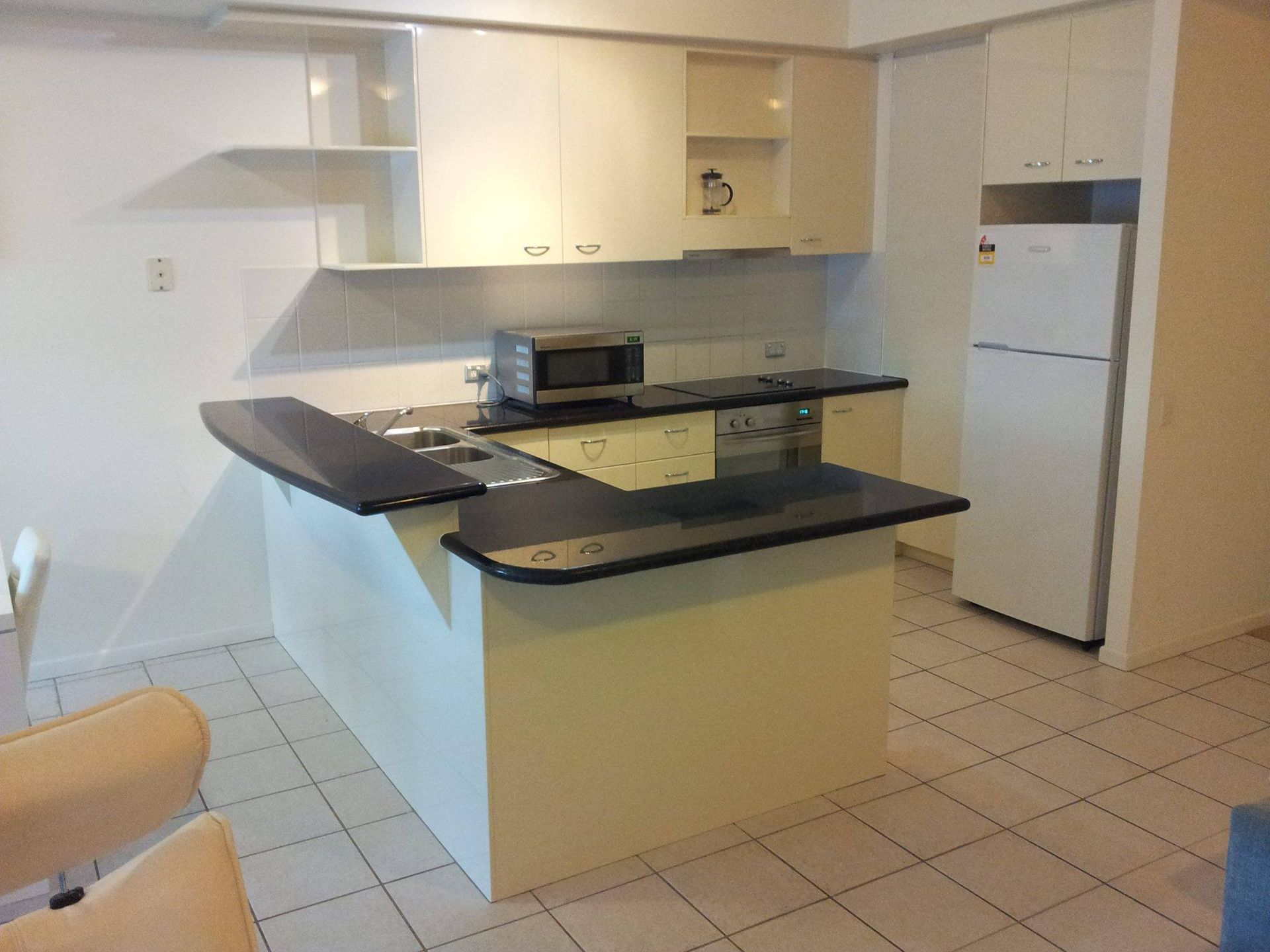 A Kitchen With White Cabinets and Black Counter Tops — Suncoast Kitchens In Gympie, QLD