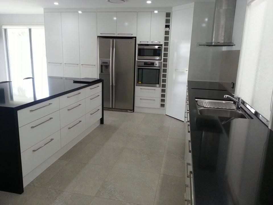A Kitchen With Stainless Steel Appliances and Black Counter Tops — Suncoast Kitchens In Caboolture, QLD