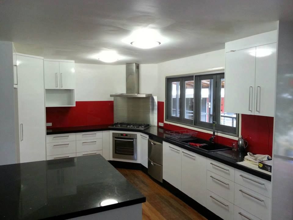 A Kitchen With White Cabinets and Black Counter Tops — Suncoast Kitchens In Caboolture, QLD
