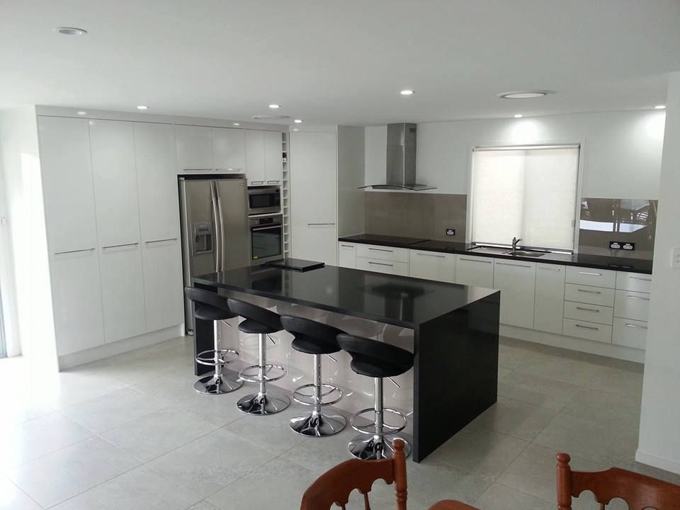 A Kitchen With White Cabinets and Black Counter Tops — Suncoast Kitchens In Tanawha, QLD