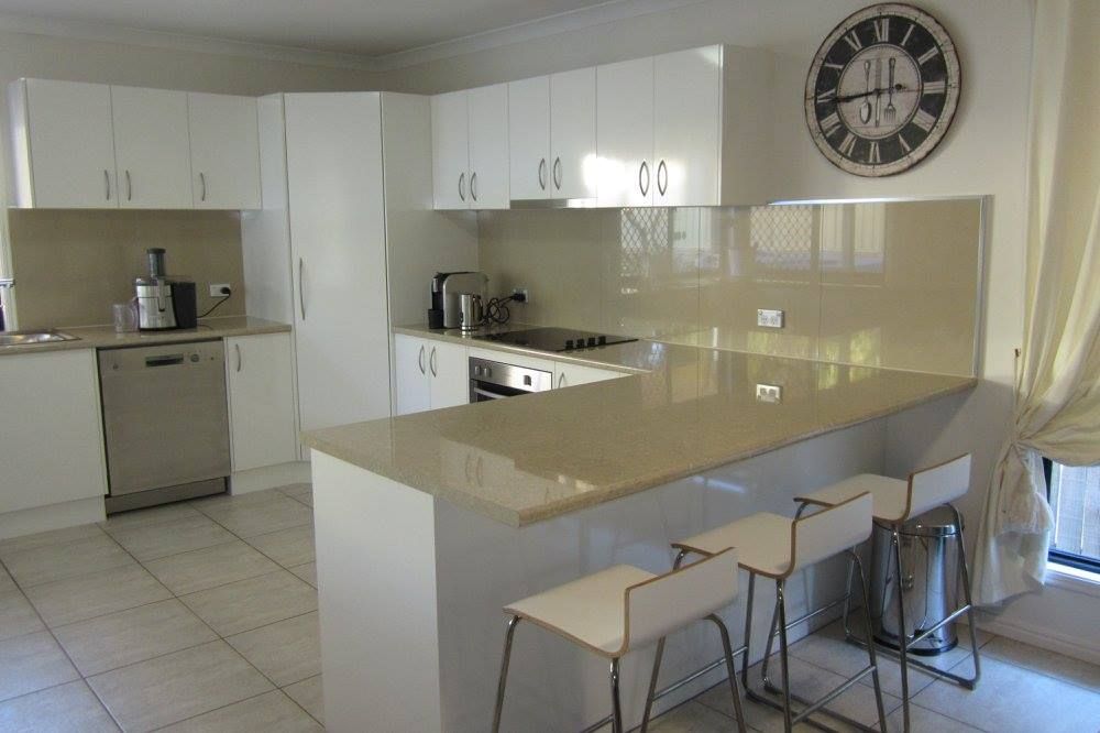 A Kitchen With White Cabinets and a Clock on the Wall — Suncoast Kitchens In Tanawha, QLD