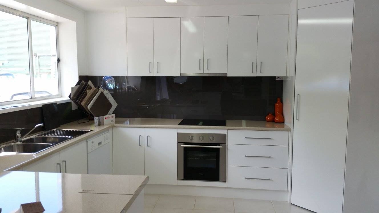 A Kitchen With White Cabinets and Black Counter Tops — Suncoast Kitchens In Tanawha, QLD