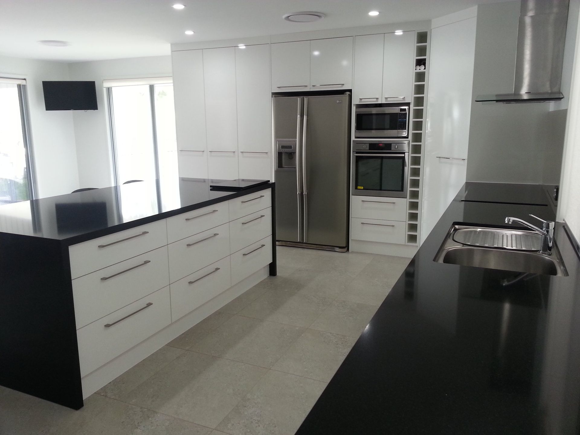 A Kitchen With Stainless Steel Appliances and Black Counter Tops — Suncoast Kitchens In Buderim, QLD