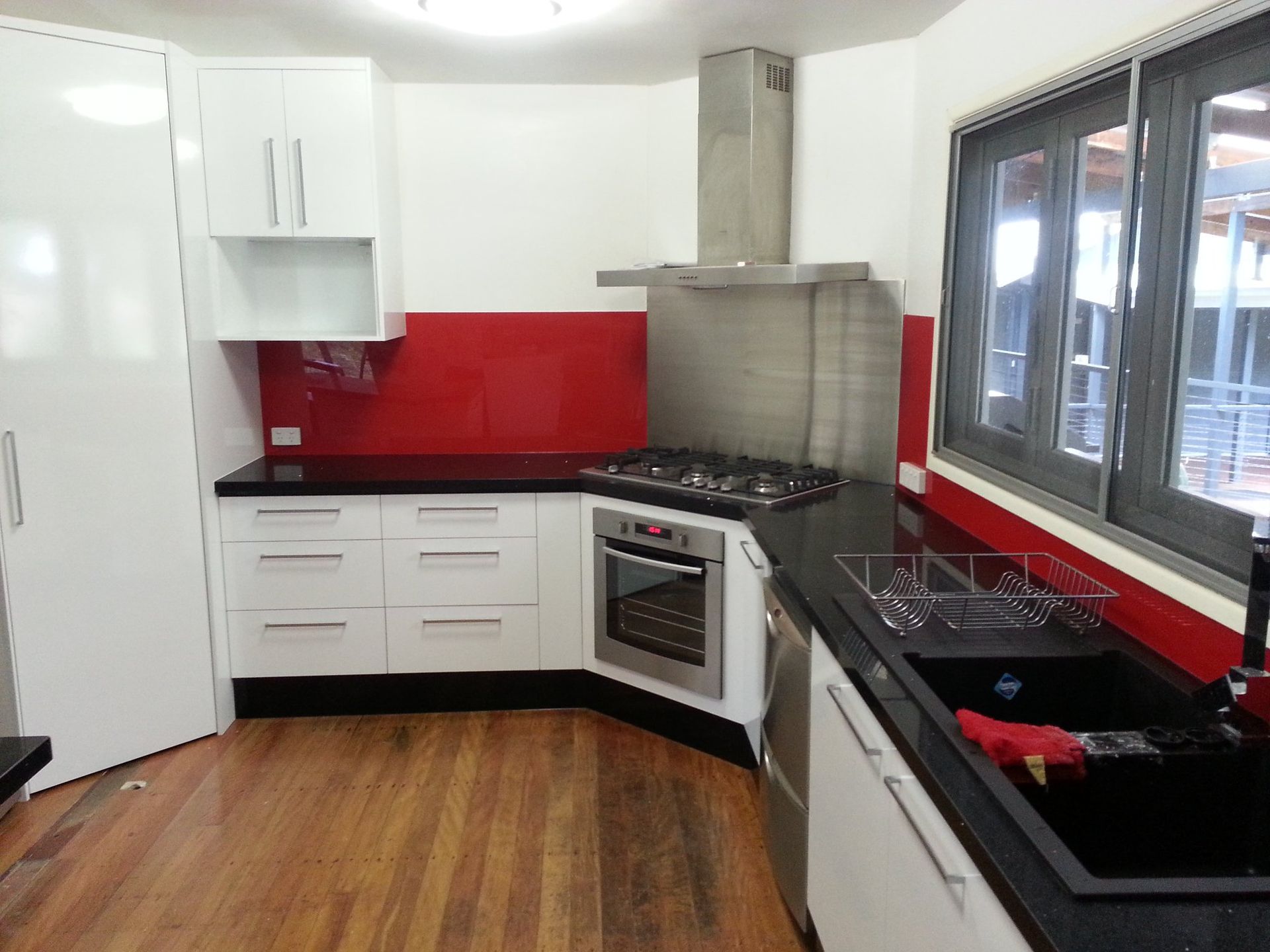 A Kitchen With White Cabinets and Black Counter Tops — Suncoast Kitchens In Bli Bli, QLD