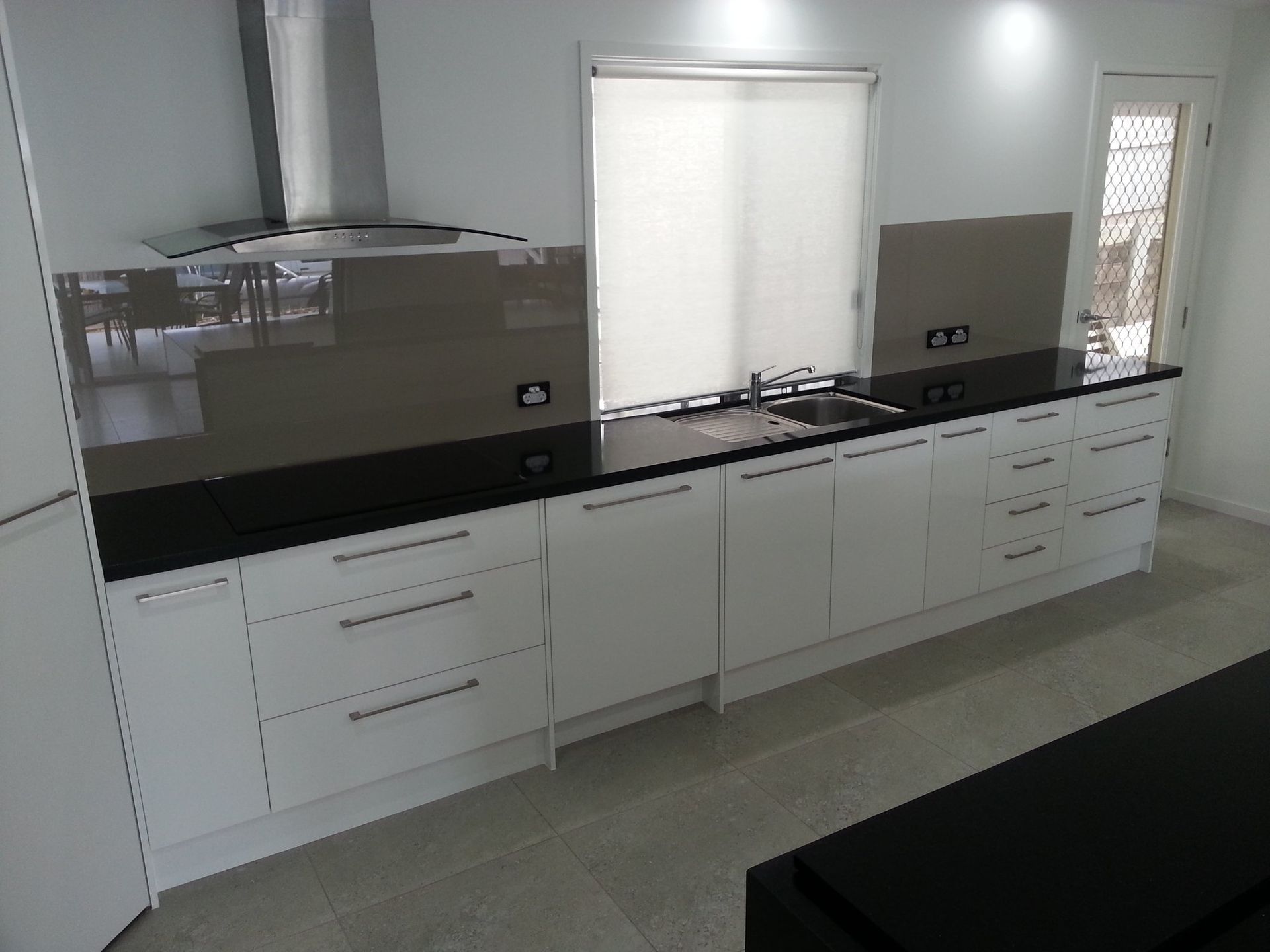 A Kitchen With White Cabinets and Black Counter Tops — Suncoast Kitchens In Maroochydore, QLD