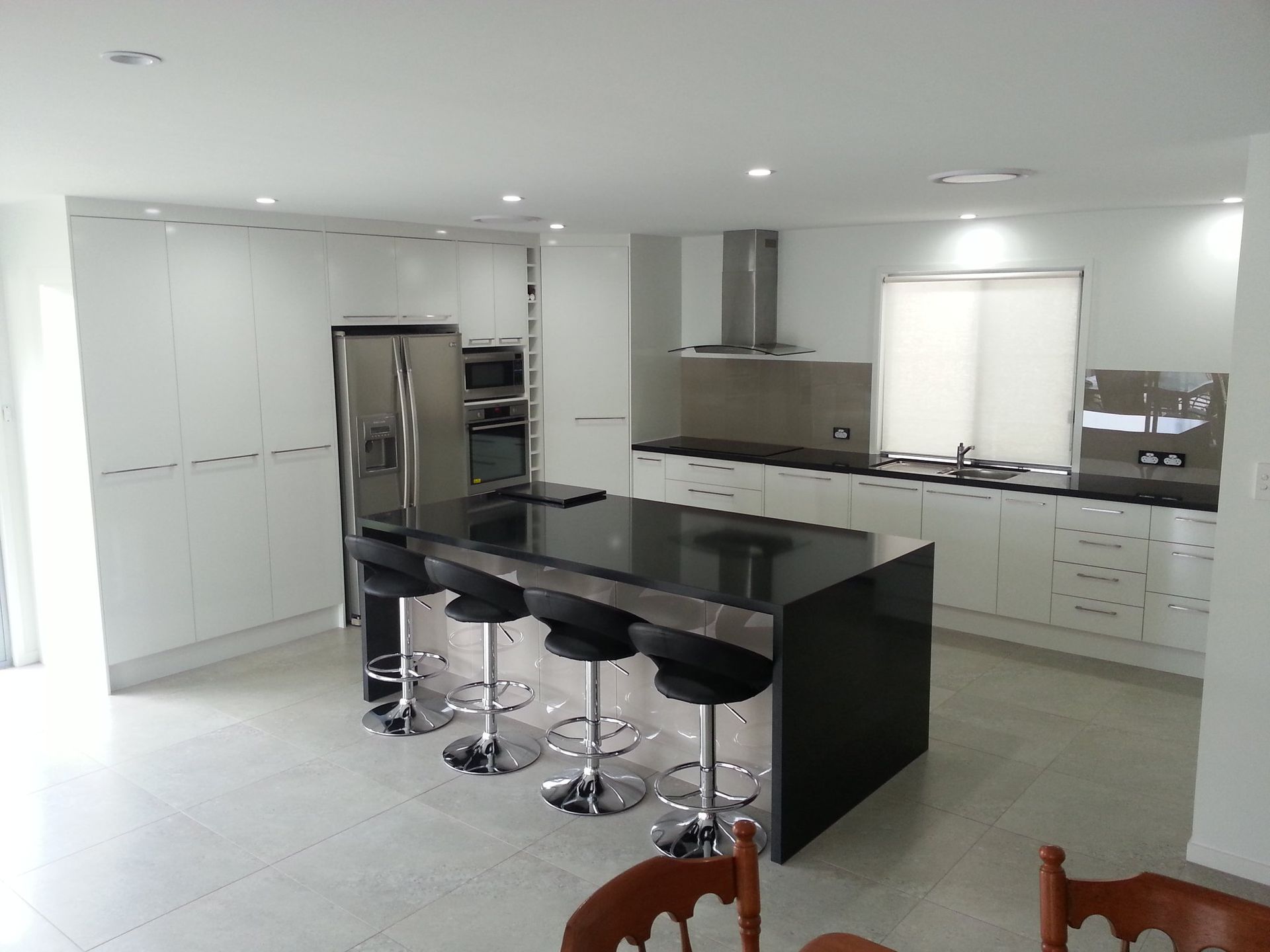 A Kitchen With White Cabinets and Black Counter Tops — Suncoast Kitchens In Maroochydore, QLD