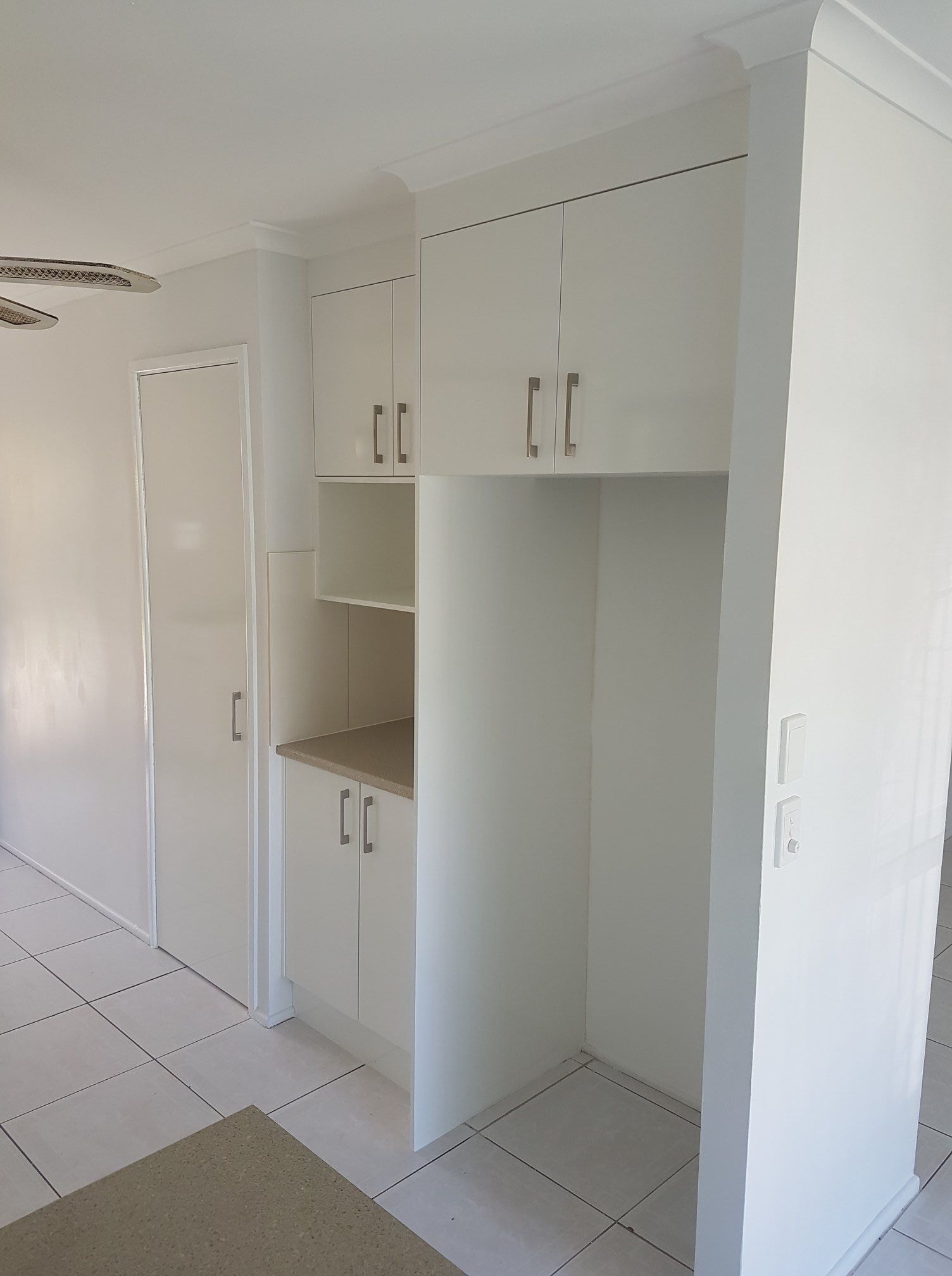 A Corner of a Room With White Cabinets and Shelves — Suncoast Kitchens In Kunda Park, QLD