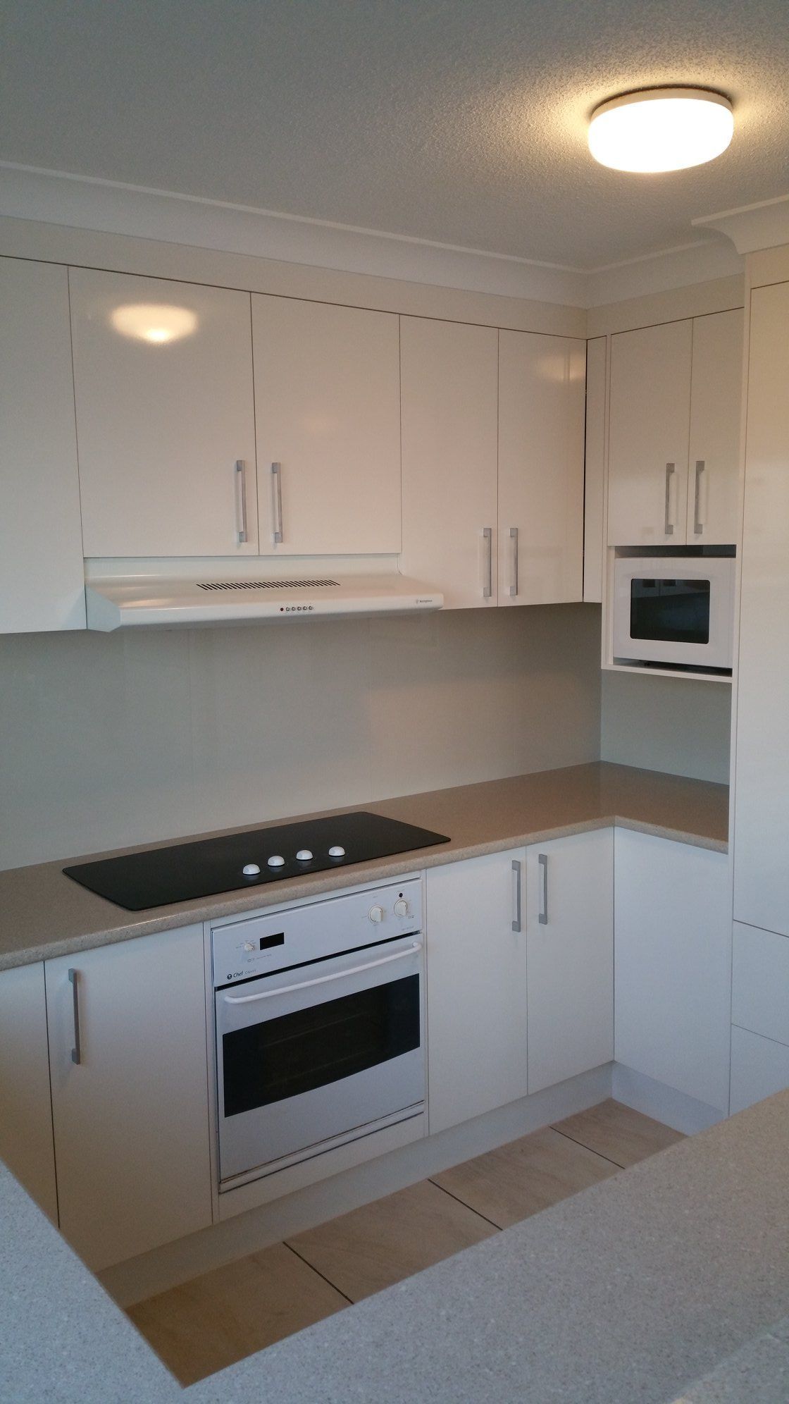 A Kitchen With White Cabinets and a Stove Top Oven — Suncoast Kitchens In Kunda Park, QLD