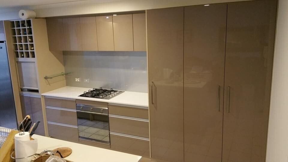 A Kitchen With a Stove Top Oven, a Refrigerator, and a Wine Rack — Suncoast Kitchens In Kunda Park, QLD
