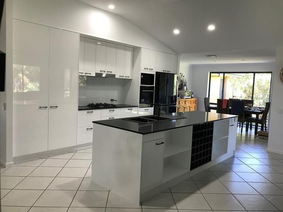 A Kitchen With White Cabinets and a Black Counter Top — Suncoast Kitchens In Kunda Park, QLD
