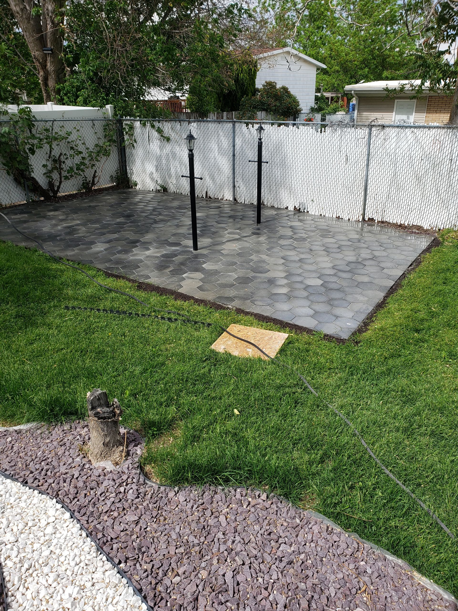 A backyard with a concrete patio and a fence.